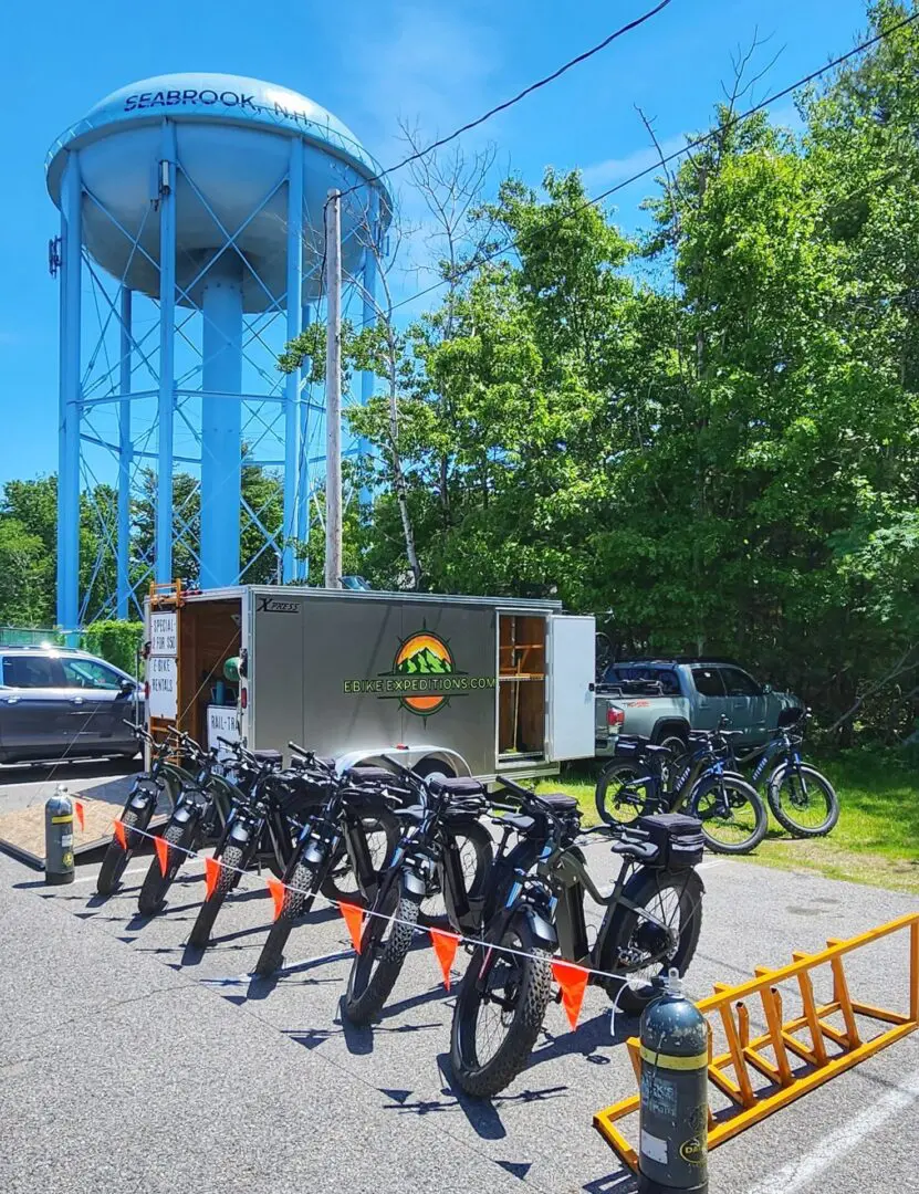 A group of bicycles parked in front of a water tower.